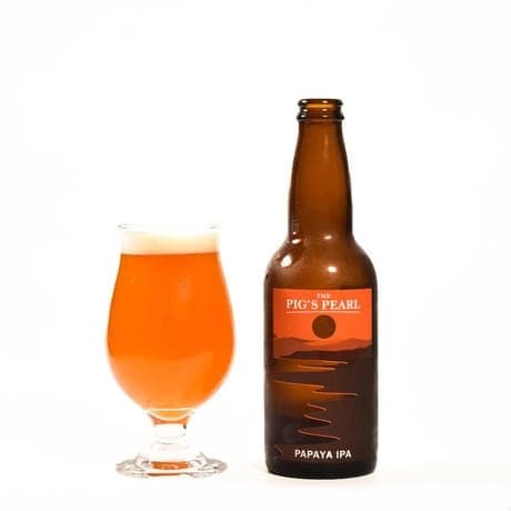 THE PIG'S PEARL PAPAYA IPAのボトル缶とグラスに注がれたビール